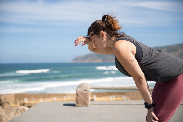 A woman rests after exercise, overlooking the ocean in Portugal's scenic seascape.